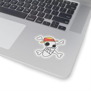 May include: A white sticker featuring a cartoon skull with crossbones, wearing a straw hat with a red band. The skull has two black eyes and a grid pattern on the lower jaw. The sticker is on a laptop.
