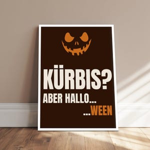 Könnte beinhalten: Ein rechteckiges Poster mit dunkelbraunem Hintergrund und einem orangefarbenen Kürbisgesicht im oberen Bereich. Der Text KÜRBIS? ABER HALLO... ...WEEN ist in weißer und orangefarbener Schrift mittig auf dem dunkelbraunen Grund platziert.
