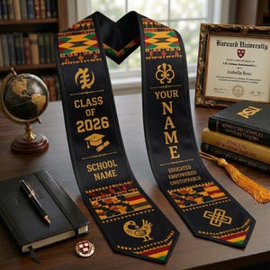 Puede incluir: Banda de graduación negra con texto dorado y coloridos patrones de inspiración africana. La banda dice "Clase de 2026" y "Tu nombre". Un diploma, libros y un globo terráqueo están en el fondo.