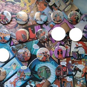 Può includere: Una collezione di spille rotonde con varie illustrazioni a fumetti colorate del personaggio Deadpool in pose d'azione, con alcune spille che mostrano nuvolette di testo e scritte, disposte su uno sfondo di pagine di fumetti.