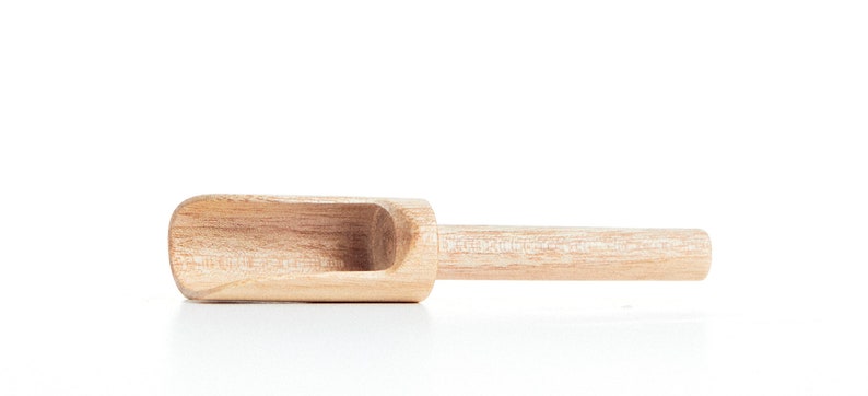 May include: A wooden scoop with a rounded handle. The scoop is made of light brown wood and has a smooth finish.