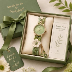 Puede incluir: Un reloj analógico dorado con esfera verde claro y correa de ganchillo verde con detalles florales blancos. El reloj se presenta en una caja de regalo verde con una etiqueta que dice Specially For You y una tarjeta con Timeless Beauty, Handmade with Love.