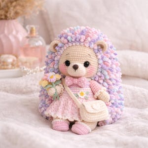 May include: A handmade crochet hedgehog doll with a light beige face, pink cheeks, and large black eyes. It wears a pink dress, a bow tie, and a small purse. The hedgehog holds a bouquet of flowers and has a multi-colored, fluffy back.