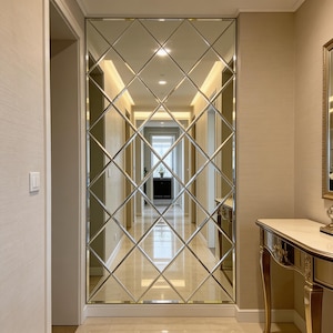 May include: A large wall mirror with a geometric diamond pattern. The mirror is installed in a hallway, reflecting the space and adding depth. The frame is not visible, creating a seamless look.