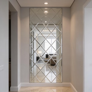 May include: A tall, rectangular wall mirror featuring a decorative diamond-shaped grid pattern across its surface. The mirror is composed of multiple individual glass panels joined together, creating a reflective, geometric lattice design.