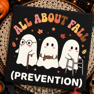 Puede incluir: Un letrero rectangular negro con el texto ALL ABOUT FALL (PREVENTION) en letras de estilo retro. El diseño incluye tres fantasmas blancos: uno con gafas y bastón, uno con cinturón y otro usando un andador, rodeados de pequeñas hojas naranjas.
