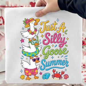 Könnte beinhalten: Weißes quadratisches Kissen mit einer farbenfrohen Grafik von drei übereinander gestapelten Cartoon-Gänsen. Die obere Gans trägt einen Hut und eine Blumenkette. Die mittlere Gans hat einen Schnorchel und die untere Gans trägt Sonnenbrille und Badehose. Der Text lautet "Just A Silly Goose Summer."