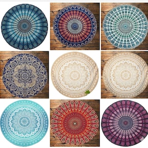 Op de afbeelding: Negen ronde mandala-wandkleden in verschillende kleuren, waaronder blauw, rood, groen en beige. Elk wandkleed heeft ingewikkelde patronen die vanuit het midden uitstralen en een symmetrisch ontwerp creëren. De wandkleden worden op een houten oppervlak getoond.