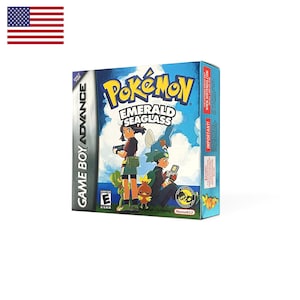 May include: A Game Boy Advance video game box for Pokémon Emerald Seaglass. The cover features two characters holding handheld consoles, accompanied by Mudkip, Treecko, and Torchic against a blue sky. The ESRB E rating is visible.