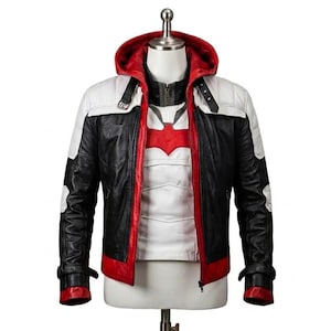 May include: A multi-colored leather jacket featuring a black body, white shoulder panels, and a red hood lining and hem. The jacket includes a front zipper, black straps with silver buckles at the shoulders, and a red emblem on the white inner shirt.