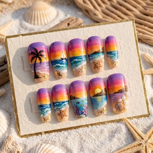 May include: A set of ten press-on nails with a beach sunset design. Each nail features a gradient of purple, orange, and yellow, with palm trees, sailboats, and starfish. The nails are displayed on a sandy surface with seashells.