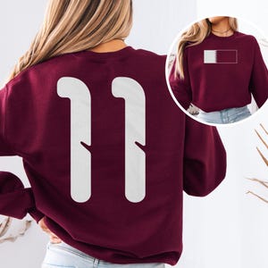 Camiseta unisex con estampado inspirado en el fútbol del número 11 de Qatar, homenaje a Estados Unidos en la Copa Mundial de Fútbol 2026, diseño casual de jugador con estampado a doble cara al estilo qatarí. imagen 9