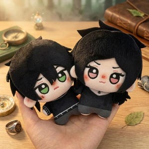 Peut inclure: Deux poupées en peluche avec des cheveux noirs et des tenues assorties. Les poupées ont de grands yeux, des joues roses et sont tenues dans une main. Les poupées sont un jouet mignon et doux.