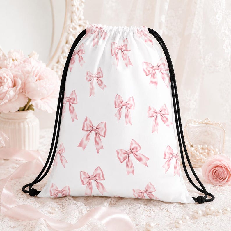 May include: White drawstring bag with a repeating pattern of pink bows. The bag has black drawstrings and is likely made of a lightweight fabric. The bows are a soft pink color, creating a feminine and delicate aesthetic. This bag is suitable for carrying items.