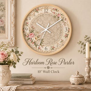 May include: A round 10-inch wall clock with a light wood frame, featuring a beige damask background, a lace-patterned border, and floral accents in pink and white. The clock face displays the text Heirloom Rose Parlor and 10" Wall Clock.