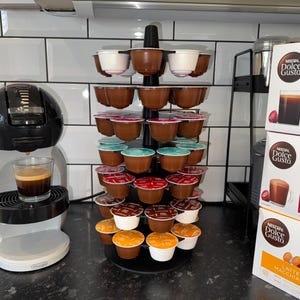 Könnte beinhalten: Ein Set aus drei Keramikbechern mit gesprenkelter, matter Oberfläche. Die Becher sind in den Farben Creme, Hellgrau und Dunkelgrau gehalten. Jeder Becher hat ein schlichtes, minimalistisches Design, ideal für Kaffee oder Tee.