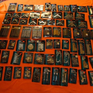 Puede incluir: Una variedad de herrajes para puertas en envases individuales, incluyendo bisagras, topes de puerta, pestillos de puerta y soportes de esquina. Los herrajes están disponibles en varios acabados, incluyendo latón, plata y negro.