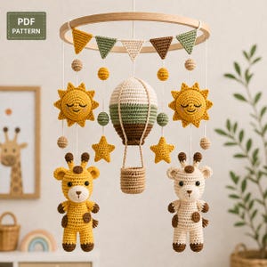 Könnte beinhalten: Handgefertigtes Baby-Mobile aus Häkelarbeit mit einem Holzring, bunten Wimpeln, Sonnen, Sternen, einem Heißluftballon und zwei Giraffenfiguren. Das Mobile wird an weißen Schnüren aufgehängt. Der Text "PDF PATTERN" befindet sich oben links.