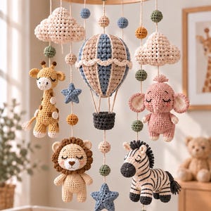 May include: A nursery mobile featuring a wooden ring frame with hanging crochet figures including a giraffe, elephant, lion, zebra, hot air balloon, clouds, stars, and small spheres in muted tones of beige, blue, pink, and green.