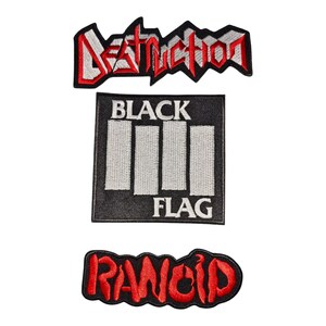 Op de afbeelding: Drie geborduurde patches met bandlogo's. De bovenste patch toont het woord DESTRUCTION in rood en wit. De middelste vierkante patch bevat vier witte verticale balken met de tekst BLACK FLAG. De onderste patch toont RANCID in rode letters.