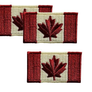 Puede incluir: Tres parches bordados con la bandera canadiense. Cada parche tiene un borde rojo y un diseño central de hoja de arce roja sobre un fondo blanco. Los parches rectangulares tienen una apariencia cosida.