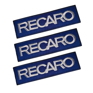 May include: Three rectangular blue patches with the word "RECARO" embroidered in white. The patches are arranged in a stack, with the text centered on each patch. The background is plain white.