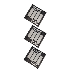 May include: Three square embroidered patches featuring a black background with four vertical white bars and the text BLACK FLAG printed in white capital letters. Each patch has a distinct border and a textured fabric surface with visible stitching.