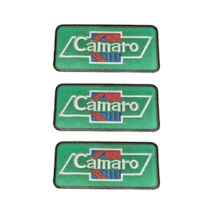 May include: Three rectangular embroidered patches featuring a green background with a white border. Each patch displays the word Camaro in white text, centered within a stylized emblem containing red and blue geometric patterns.