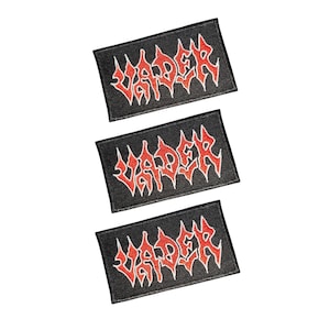 Pode incluir: Três emblemas retangulares bordados com fundo preto e a palavra VADER costurada numa fonte vermelha estilizada e irregular com um contorno branco fino. Cada emblema tem um design consistente e uma borda preta em torno das extremidades.