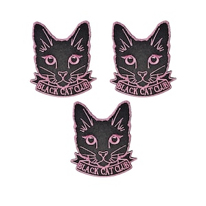 May include: Three black cat patches with pink embroidery. Each patch shows a cat face with the text "BLACK CAT CLUB" on a banner. The patches are set against a white background.