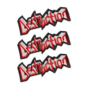 May include: Three identical embroidered patches featuring the word DESTRUCTION in a jagged, stylised red font with white fill and a thick black border. Each patch has a sharp, angular shape with a distinct, aggressive lettering design.