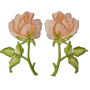 Puede incluir: Dos parches bordados de rosas. Cada parche presenta una rosa de color melocotón claro con detalles en naranja, tallos verdes y hojas verdes. Los parches están diseñados para ser cosidos a la tela.