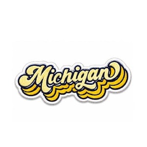 May include: An embroidered patch featuring the word Michigan in a stylized, cursive font. The lettering is yellow with a dark blue outline, layered over a repeating, wavy yellow and dark blue shadow effect that creates a dimensional appearance.