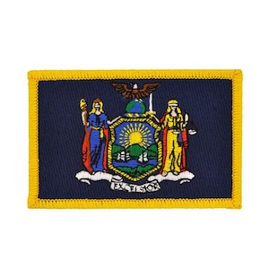 May include: A rectangular embroidered patch featuring the New York state flag design on a dark blue background with a yellow border. The central emblem depicts two figures, a shield with a sun over mountains and water, an eagle, and the word EXCELSIOR.
