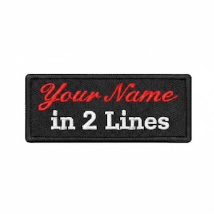 Pode incluir: Um emblema retangular preto bordado com borda costurada. A linha superior apresenta o texto "Your Name" em letra cursiva vermelha, e a linha inferior exibe o texto "in 2 Lines" em letras de forma brancas sobre um fundo preto.