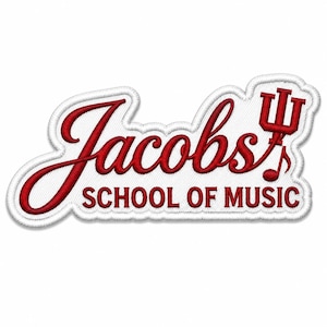 以下が含まれることがあります： 赤色の筆記体とブロック体で「Jacobs SCHOOL OF MUSIC」と書かれた刺繍パッチ。パッチは白い縁取りがあり、赤い音符と三叉のシンボルが含まれています。