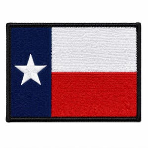 May include: A rectangular embroidered patch featuring the Texas state flag design. The patch has a vertical blue stripe on the left with a single white star, and horizontal white and red stripes on the right, all bordered by a black stitched edge.