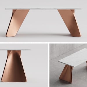 Puede incluir: Mesa de centro moderna con tapa de mármol blanco y patas de metal color cobre. Las patas tienen un diseño curvo único. La mesa mide aproximadamente 122 cm de largo y 46 cm de alto.