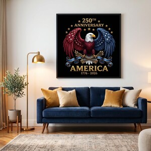 Puede incluir: Un estampado enmarcado con una ilustraci&oacute;n detallada de un &aacute;guila calva americana con alas rojas, blancas y azules. El texto dice "250th Anniversary AMERICA 1776-2026" en letras doradas sobre un fondo negro. La imagen se muestra sobre un sof&aacute; azul.