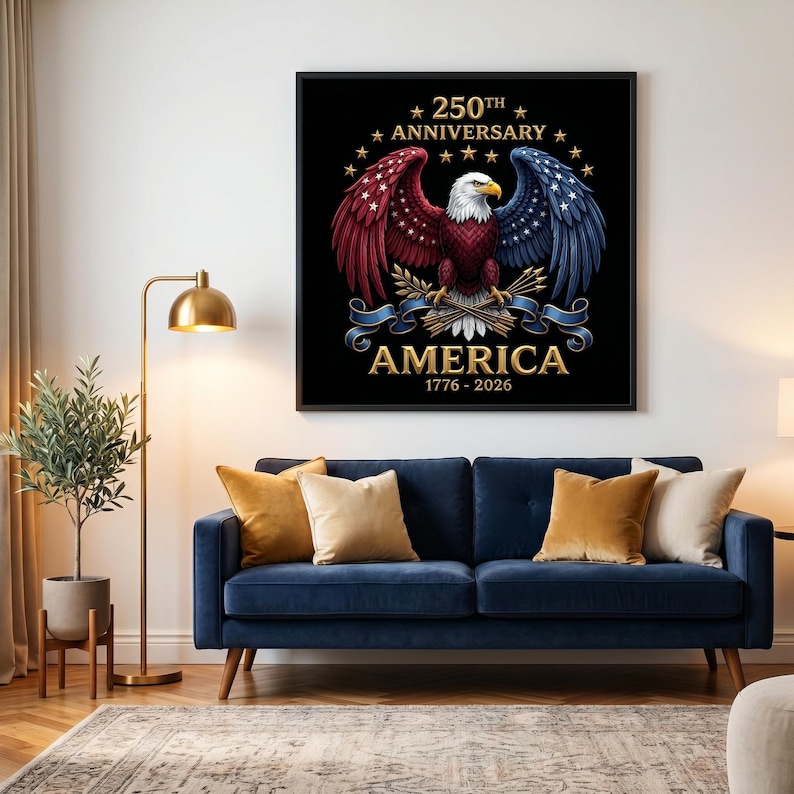 Puede incluir: Un estampado enmarcado con una ilustraci&oacute;n detallada de un &aacute;guila calva americana con alas rojas, blancas y azules. El texto dice "250th Anniversary AMERICA 1776-2026" en letras doradas sobre un fondo negro. La imagen se muestra sobre un sof&aacute; azul.