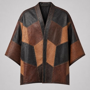 May include: A patchwork leather jacket in shades of brown and black. The jacket features a geometric design with a V-neck and short sleeves. The jacket is a unique piece of outerwear.