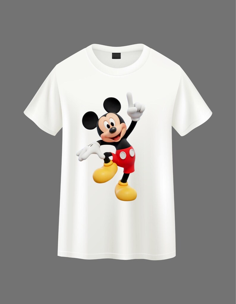 May include: A white short-sleeved t-shirt featuring a centered graphic of Mickey Mouse. The character is depicted in a dynamic pose with one hand raised, wearing red shorts with two white buttons, yellow shoes, and white gloves on a black body.