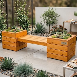 Può includere: Panca in legno con due fioriere integrate piene di piante grasse. La panca è in legno chiaro ed è circondata da un giardino con varie piante e pietre decorative. La panca è progettata per uso esterno.