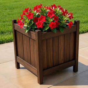 May include: A square, dark brown wooden planter box filled with vibrant red flowers and green foliage. The planter has a slatted design and is set on a stone patio with a green lawn in the background. A decorative outdoor item.