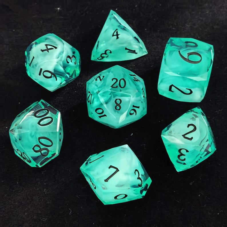 May include: A set of seven translucent mint green polyhedral dice with swirling white inclusions and black engraved numbers. The collection includes a d20, d12, d10, d8, d6, d4, and a percentile die, all featuring sharp edges and clear, legible numerals.
