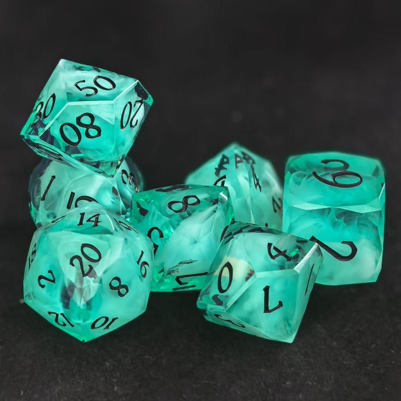 May include: A set of seven translucent teal polyhedral dice with swirling white internal patterns and bold black numbers. The collection includes various geometric shapes such as a d20, d12, d10, d8, d6, and d4, all featuring sharp edges and clear, legible ink.
