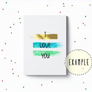 May include: A white card with the words "I love you" written in black. The words are layered over three horizontal brushstrokes in gold, blue, and green.