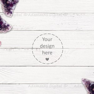 Puede incluir: Cristales de amatista morados y rosados sobre un fondo de madera blanca. El texto "Your design here" está en un círculo en el centro de la imagen.