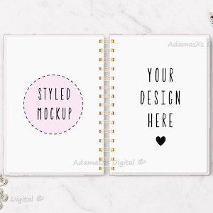 以下が含まれることがあります： 左ページに「Styled Mockup」と書かれたピンクの円、右ページに「Your Design Here」と黒いハートが書かれた白いスパイラルバインダーノートのモックアップです。