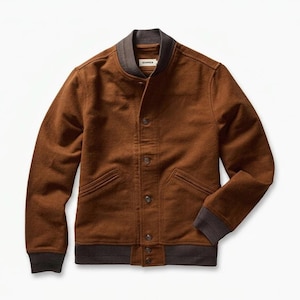 Könnte beinhalten: Braune Bomberjacke mit Knopfleiste, zwei Vordertaschen und einem dunkelgrauen Kragen, Manschetten und Saum. Die Jacke hat ein klassisches Design und ist aus weichem Material gefertigt.